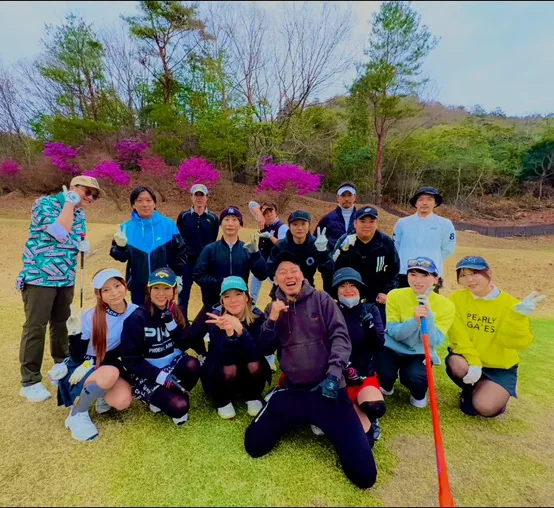 春の大会で、ツツジの咲くコースに参加者が集まった集合写真